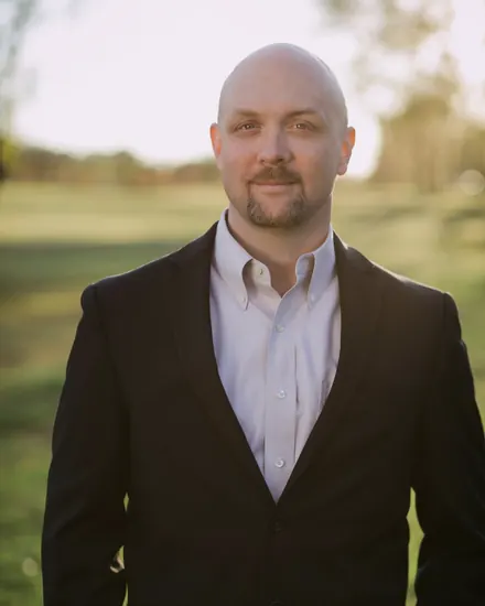 Phillip Austin Green, who runs Stonepath IT, outdoors in low evening sun, in a dark jacket over an open collar shirt.